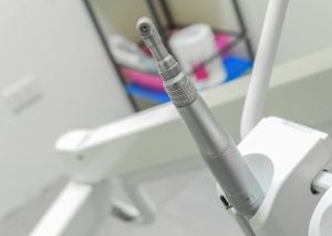 An electric handpiece displayed on a dental chair