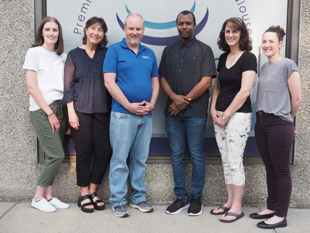 John Turner DMD standing with staff members smiling at Colfax Dental